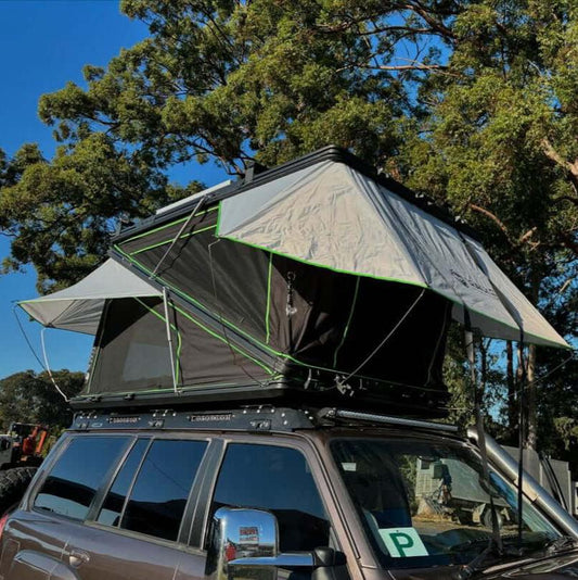 NEW Deluxe Z rooftop tent by Australias most affordable brand shown on a vehicle in a scenic outdoor setting.